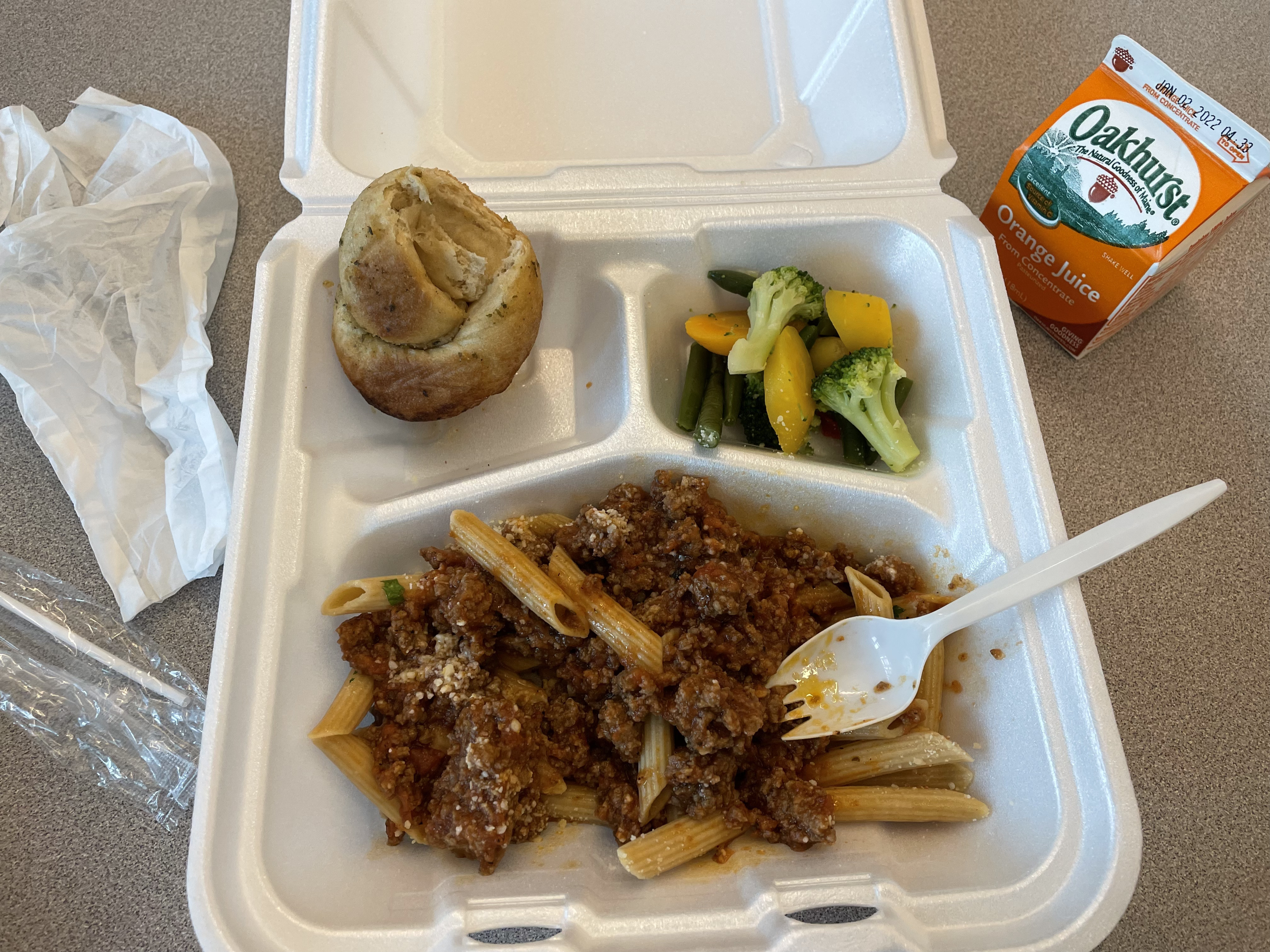 Pasta with meat and a garlic knot with vegetables